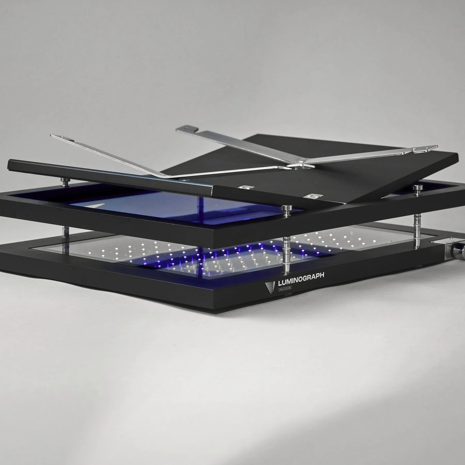 Luminograph A3+ noir, presse ouverte : plateau vitré relevé, bras levés, LED UV allumées