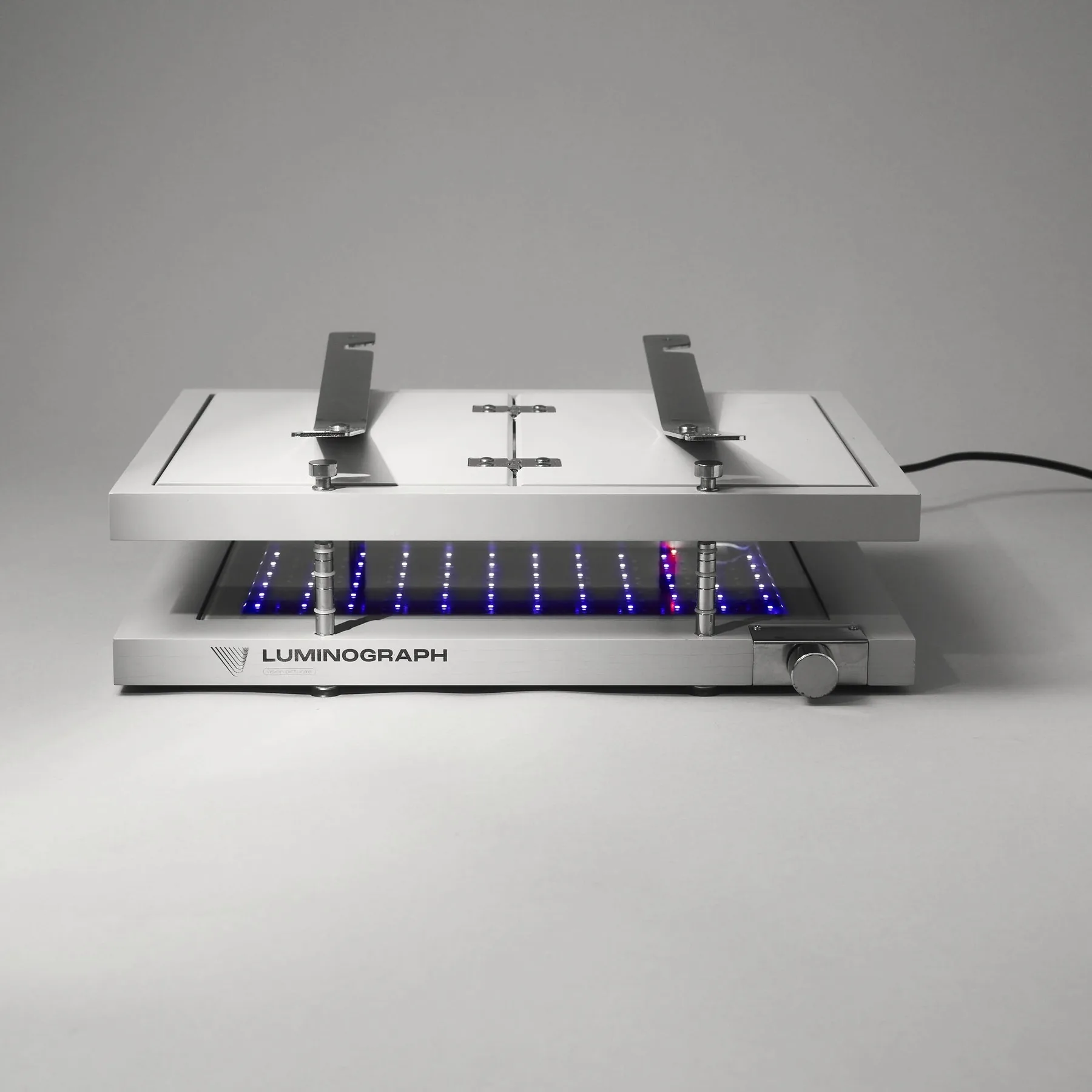 Luminograph A4 de face, presse fermée, bras rabattus, LED UV allumées sous le plateau